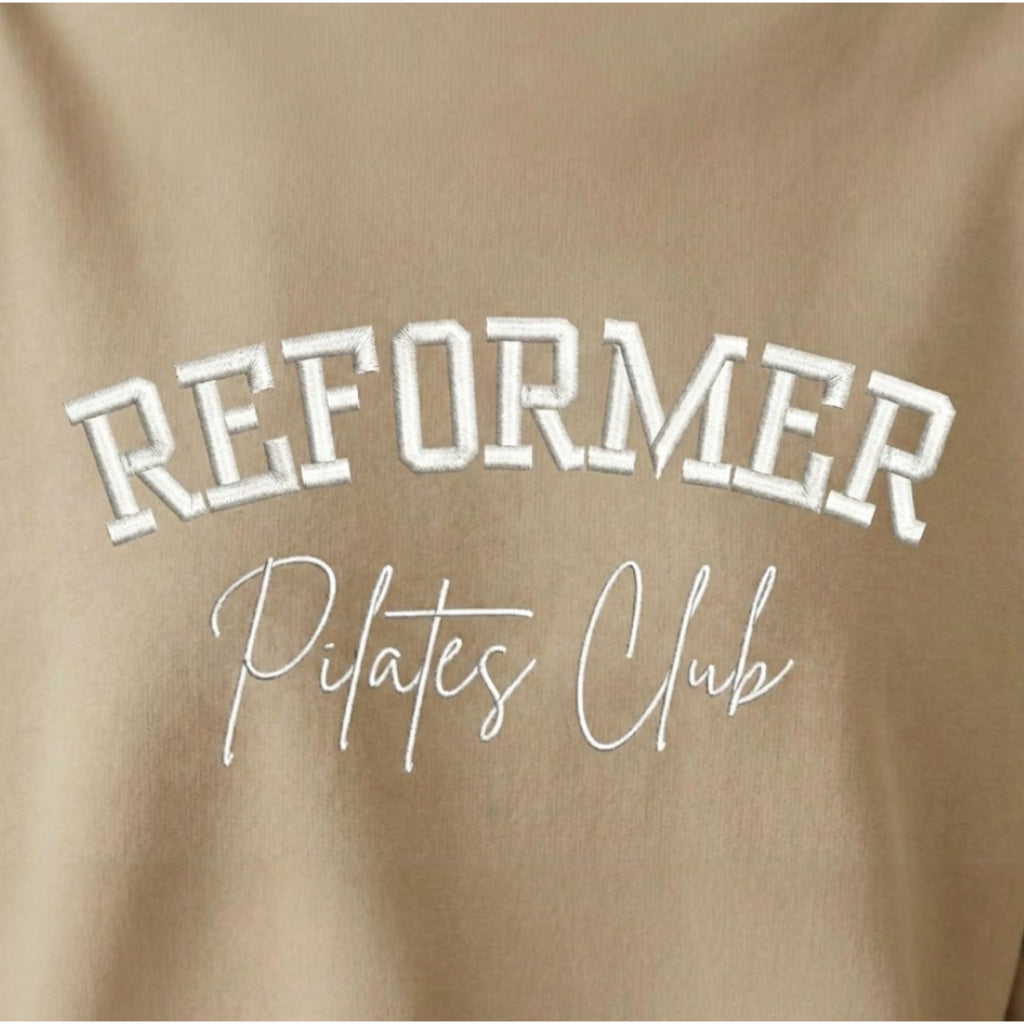 Reformer Pilates Club embroidered pink Pilates sweatshirt close up showing white embroidered lettering on fleece jumper