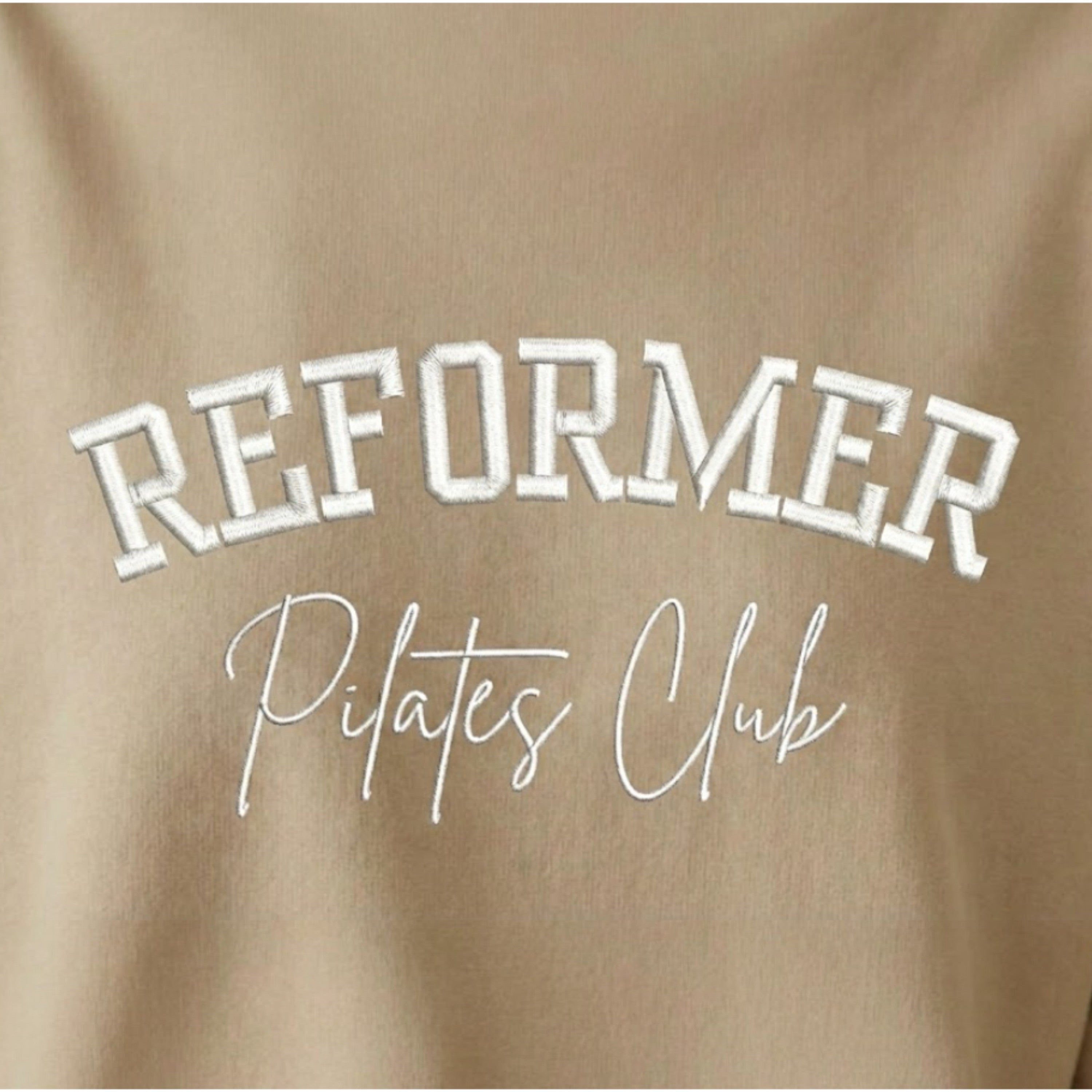 Reformer Pilates Club embroidered pink Pilates sweatshirt close up showing white embroidered lettering on fleece jumper