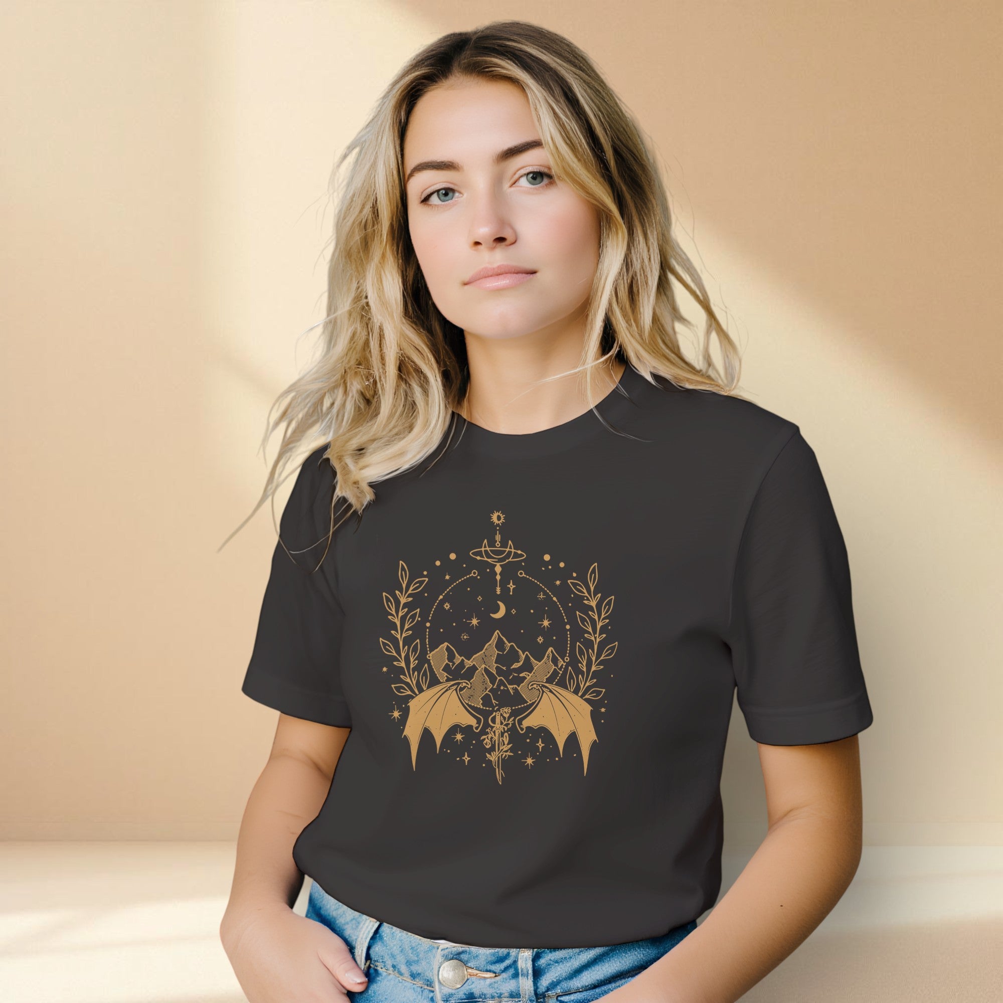 Woman wearing a black t-shirt with a gold graphic design on a beige background